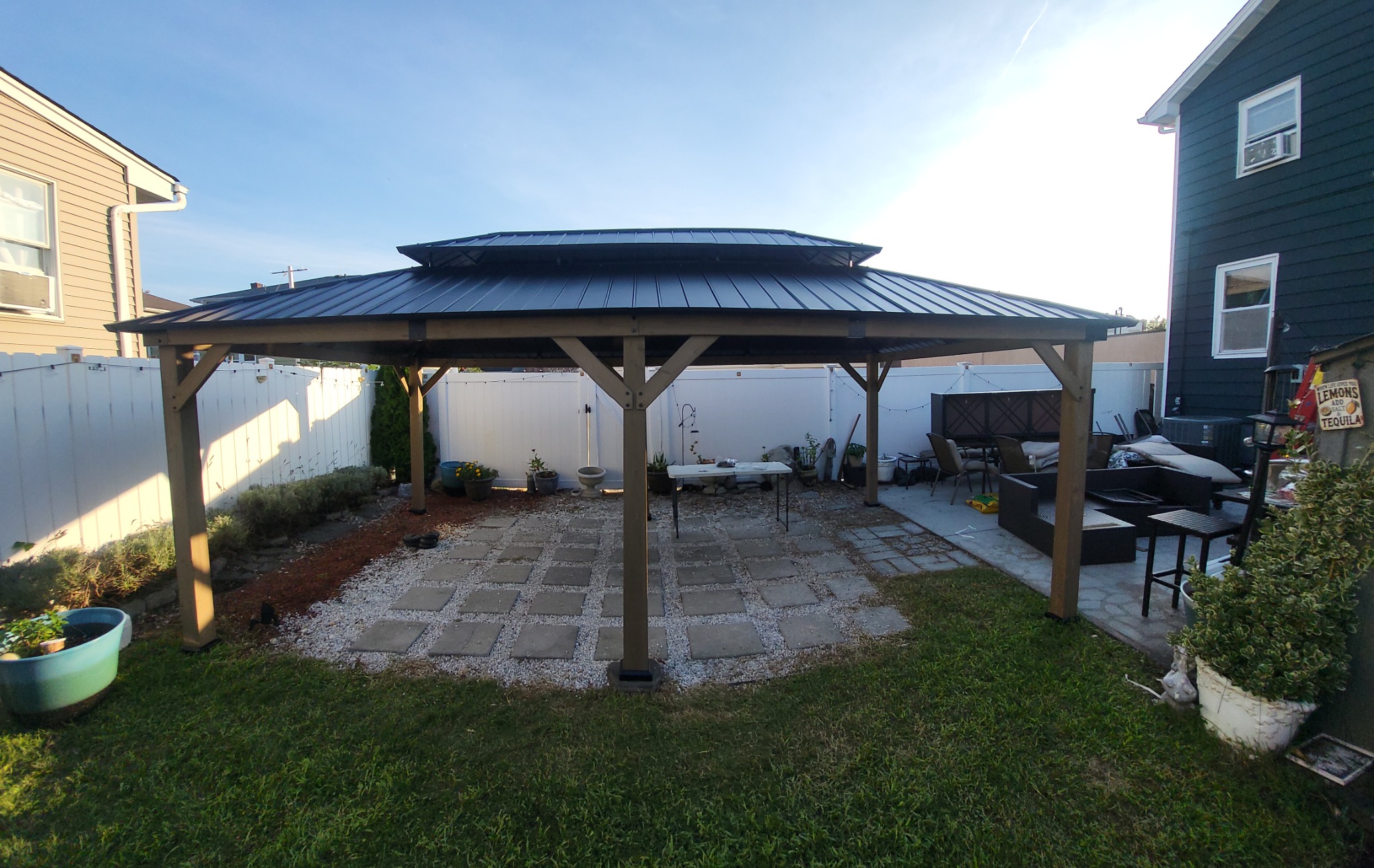 Completed backyard gazebo with tiered metal roof