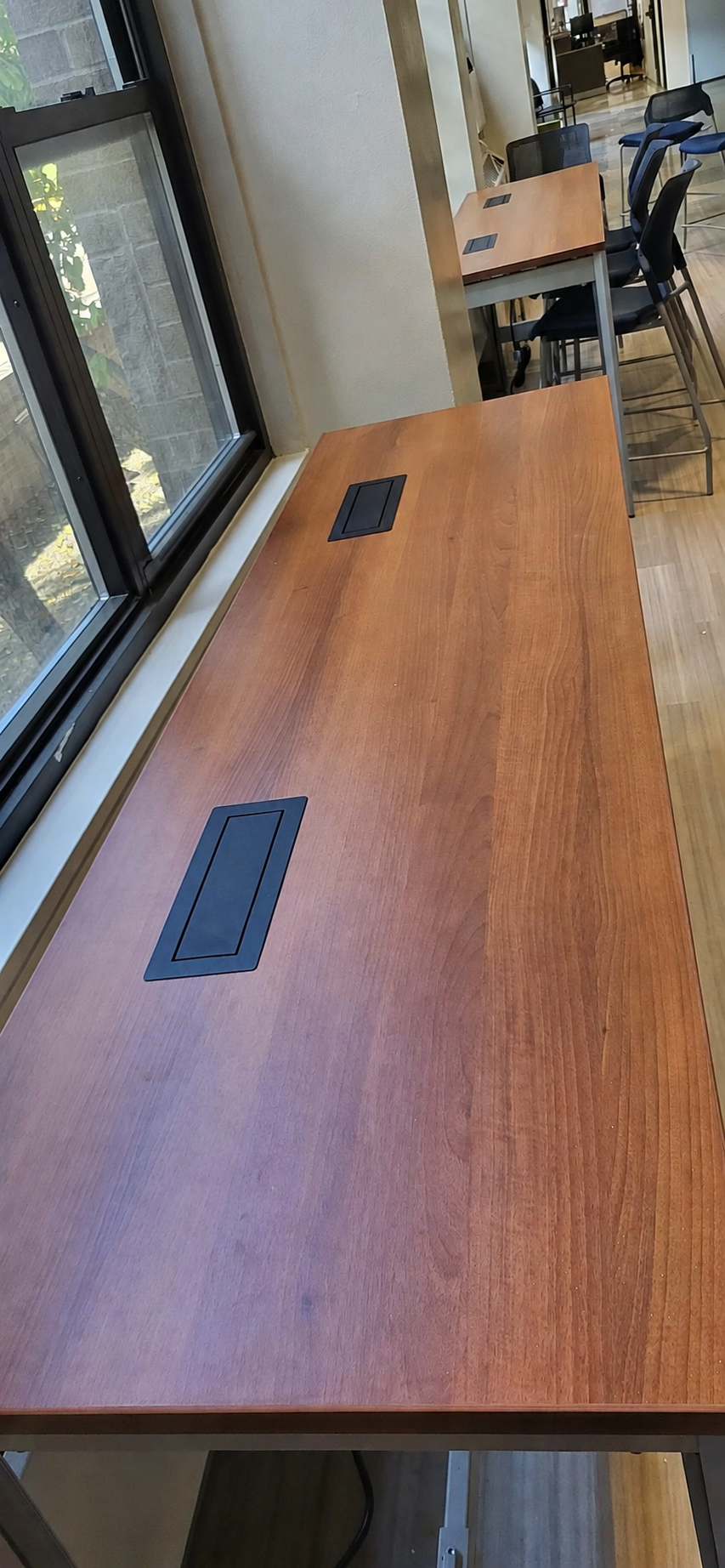 Four flush-mounted electrical modules installed in two wood worksurfaces