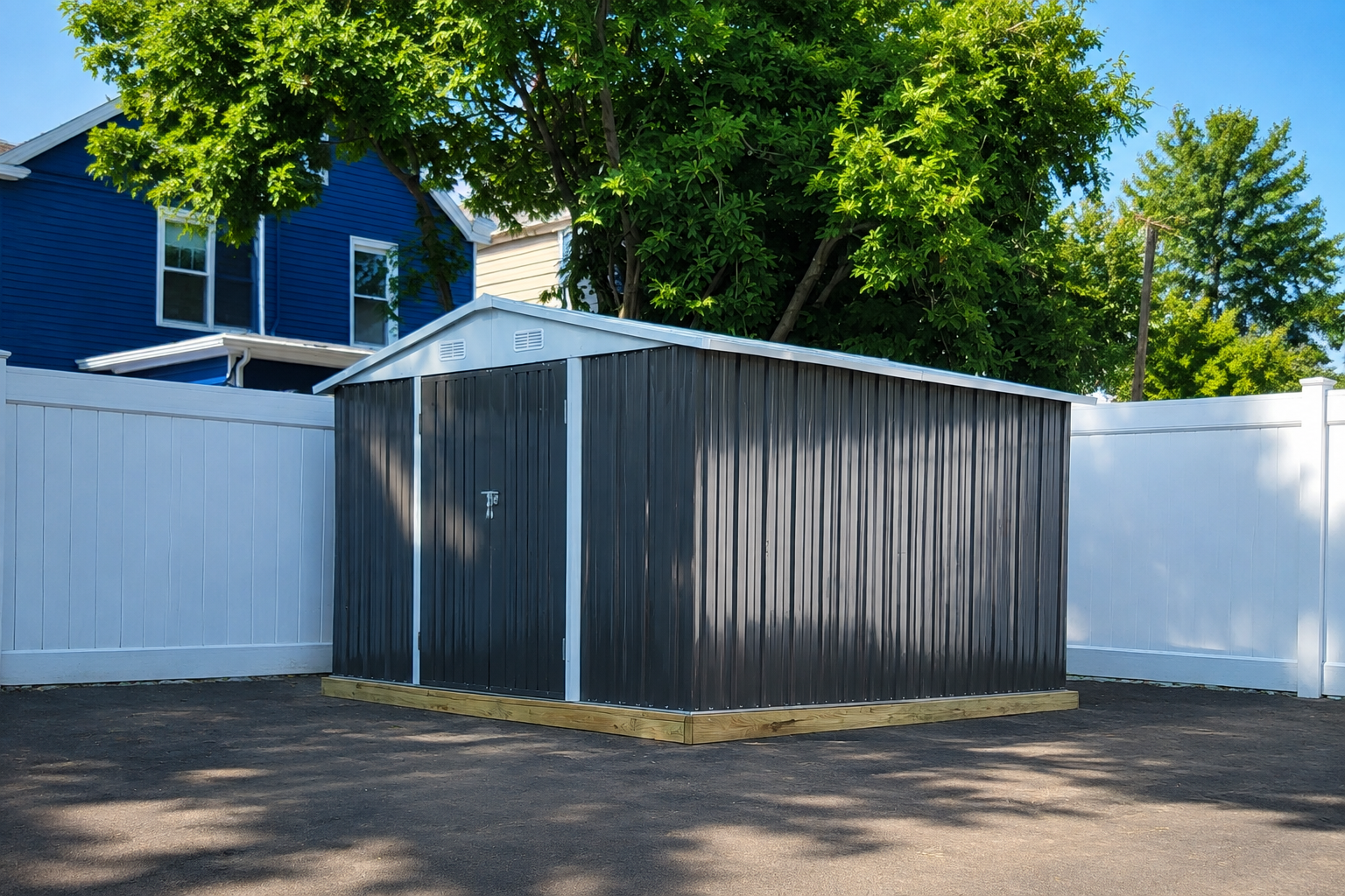 Completed dark gray metal storage shed with roof and doors installed