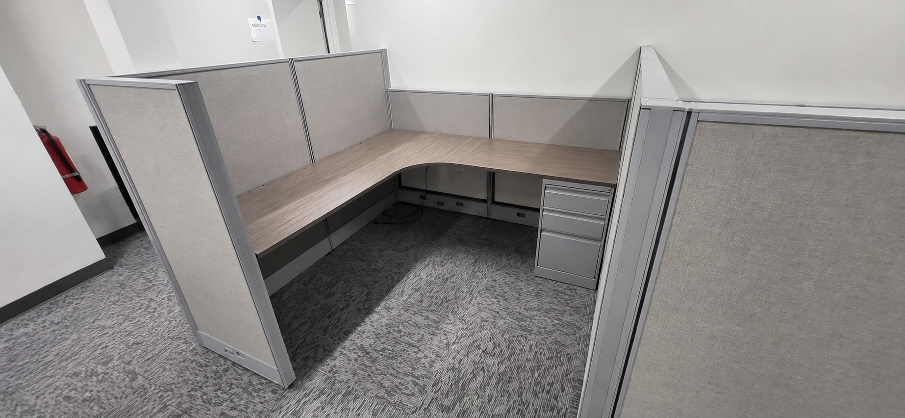 Completed private cubicle workstation with L-shaped worksurface and pedestal storage