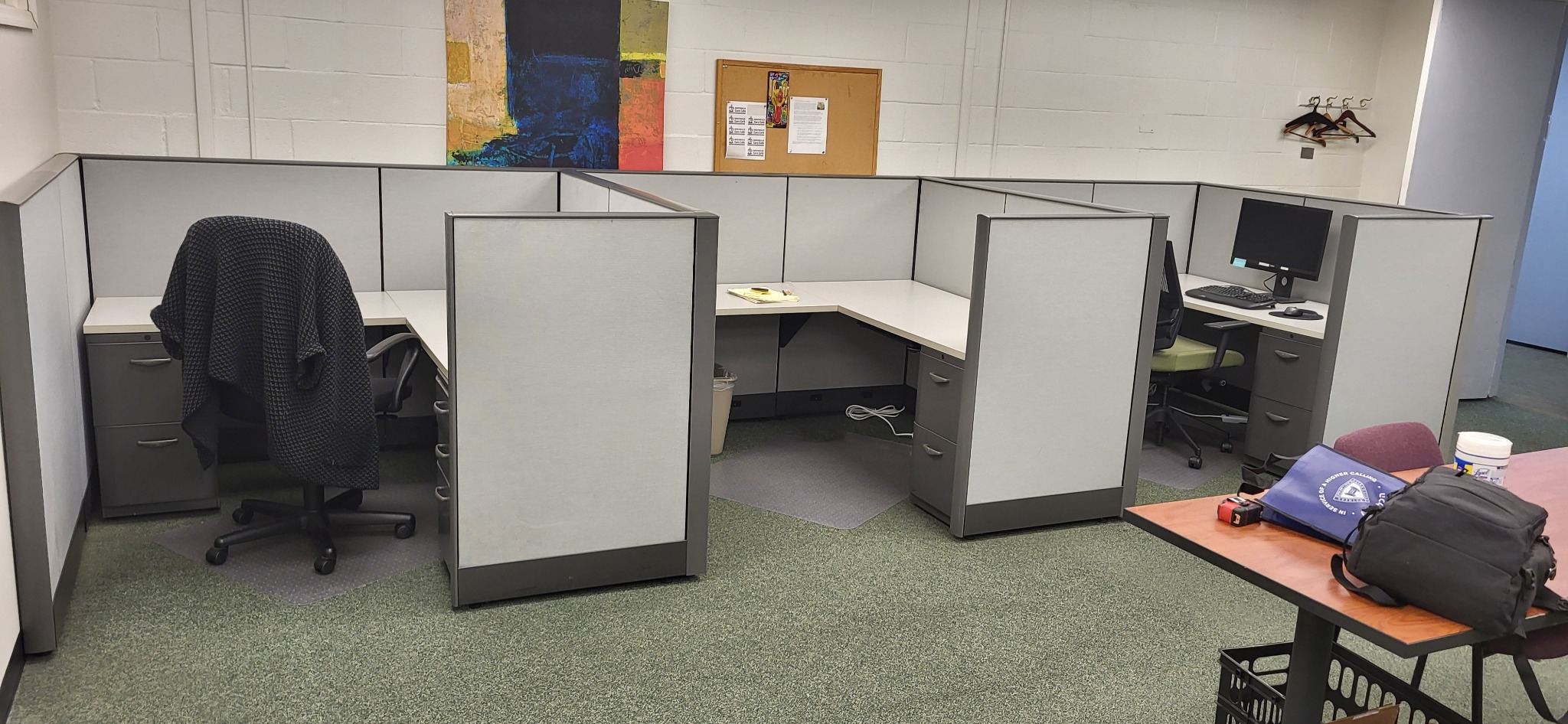 Furnished gray cubicle workspace before disassembly for reupholstery